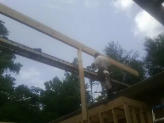 Carpenter setting a ridge beam over a new addition frame — Ice Dam Removal by Roofing Brothers in Zimmerman