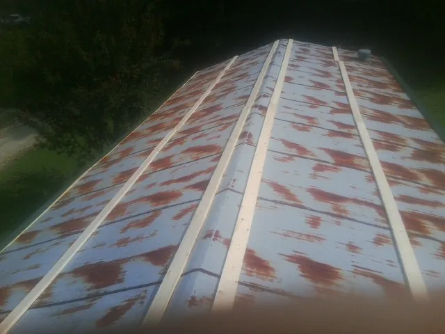 Rusted metal roof panels with new wood purlins before replacement — Storm Damage Roof Repair in Zimmerman by Roofing Brothers