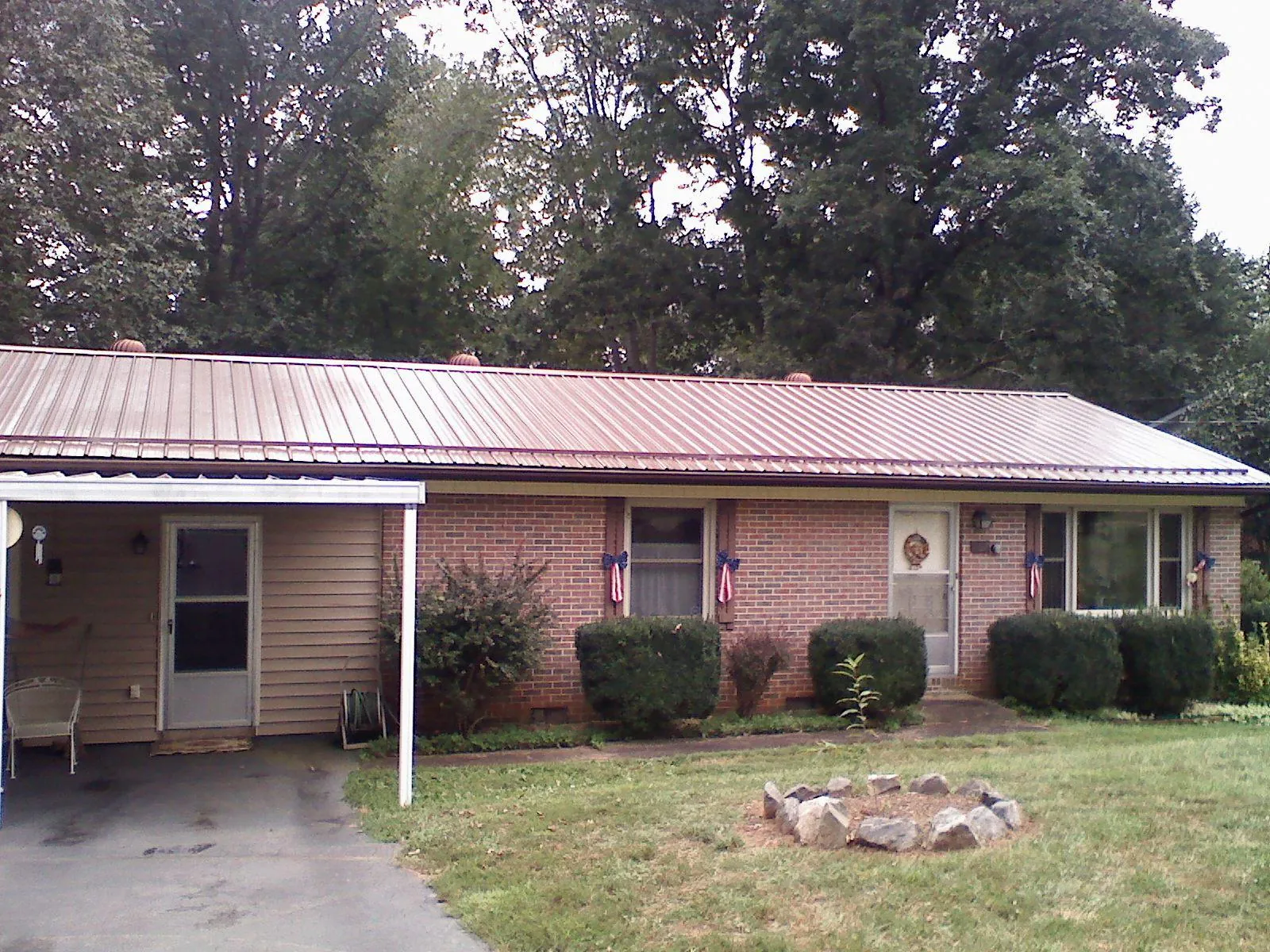 Bronze metal roof and carport on a brick ranch home — Roof Repair work by our crew in Zimmerman